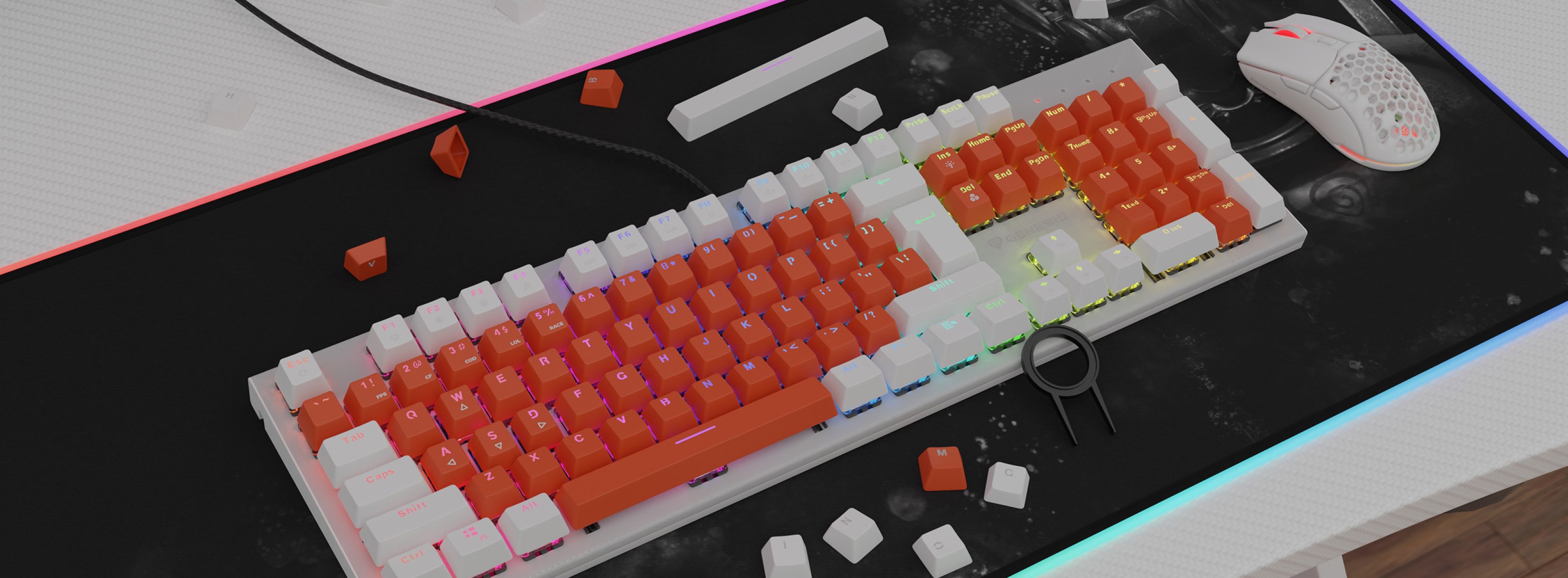 Claviers double shot orange et blanc sur un clavier mécanique, avec des claviers épars et une souris gaming blanche sur un tapis noir.