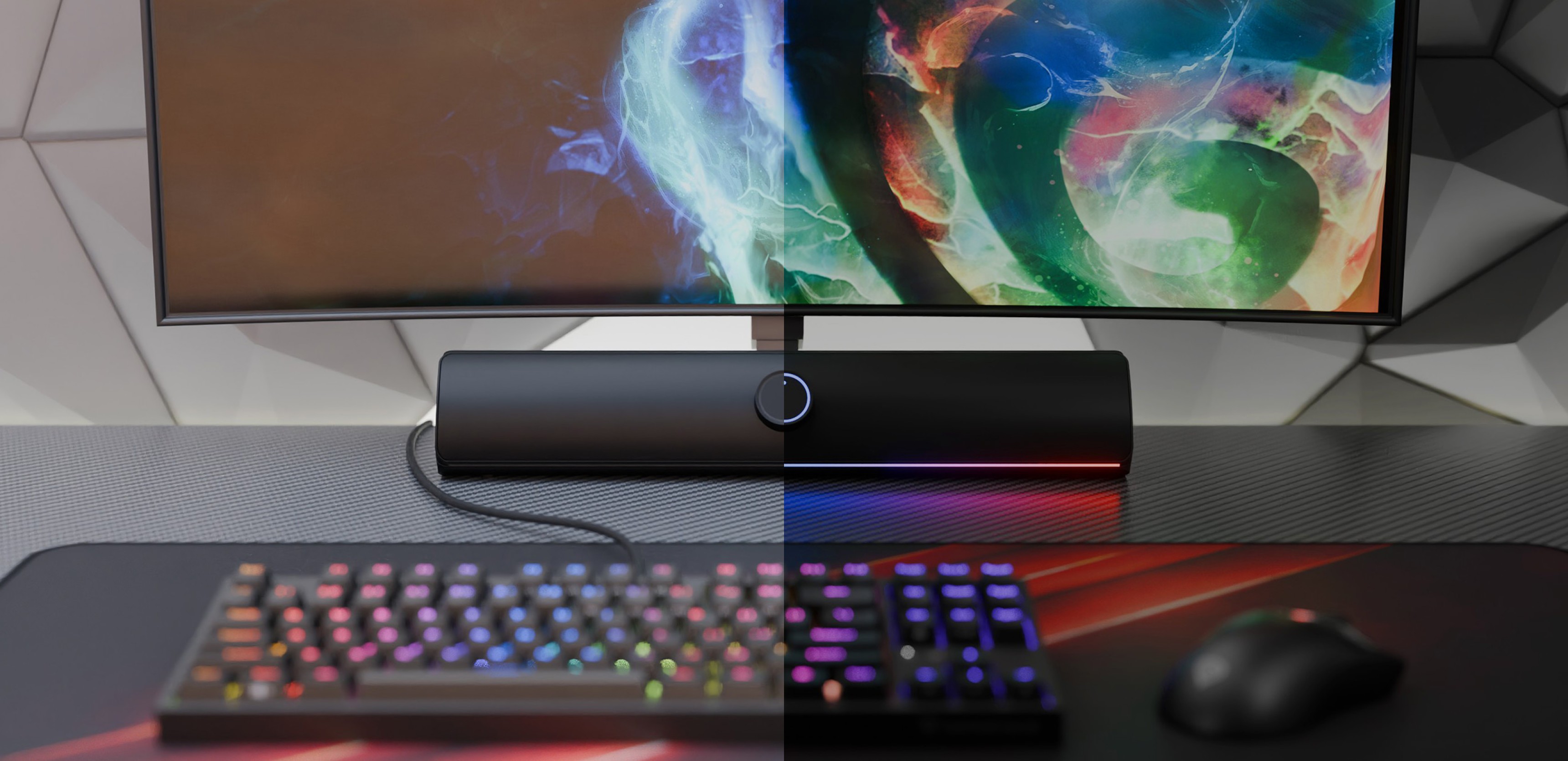 Barre de son Bluetooth noire positionnée sous un moniteur coloré, avec un clavier et une souris de jeu RVB sur un bureau.