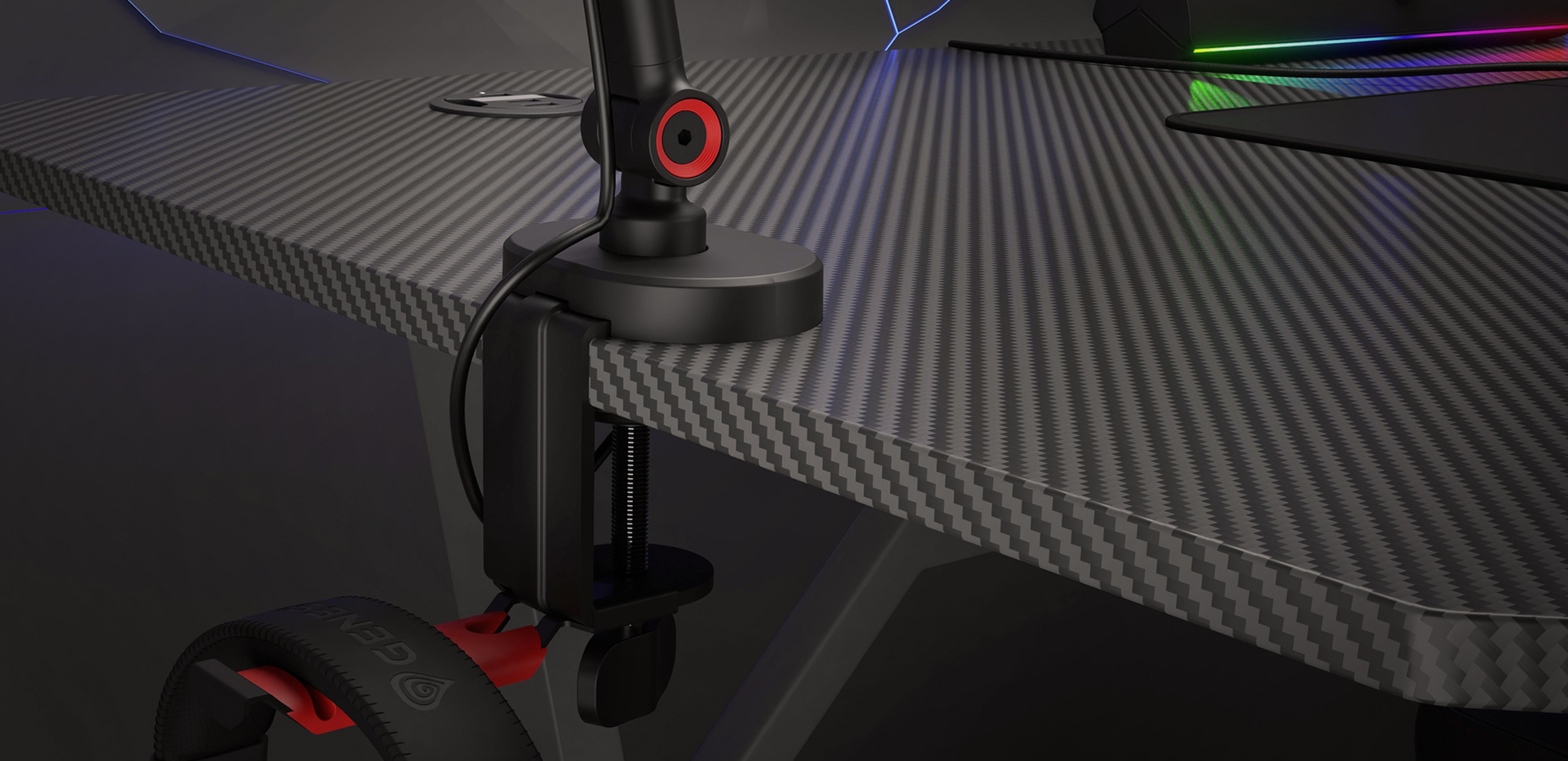 Bras de microphone fixé à un bureau de jeu avec un support pour casque, présentant un design noir élégant et des accents rouges.