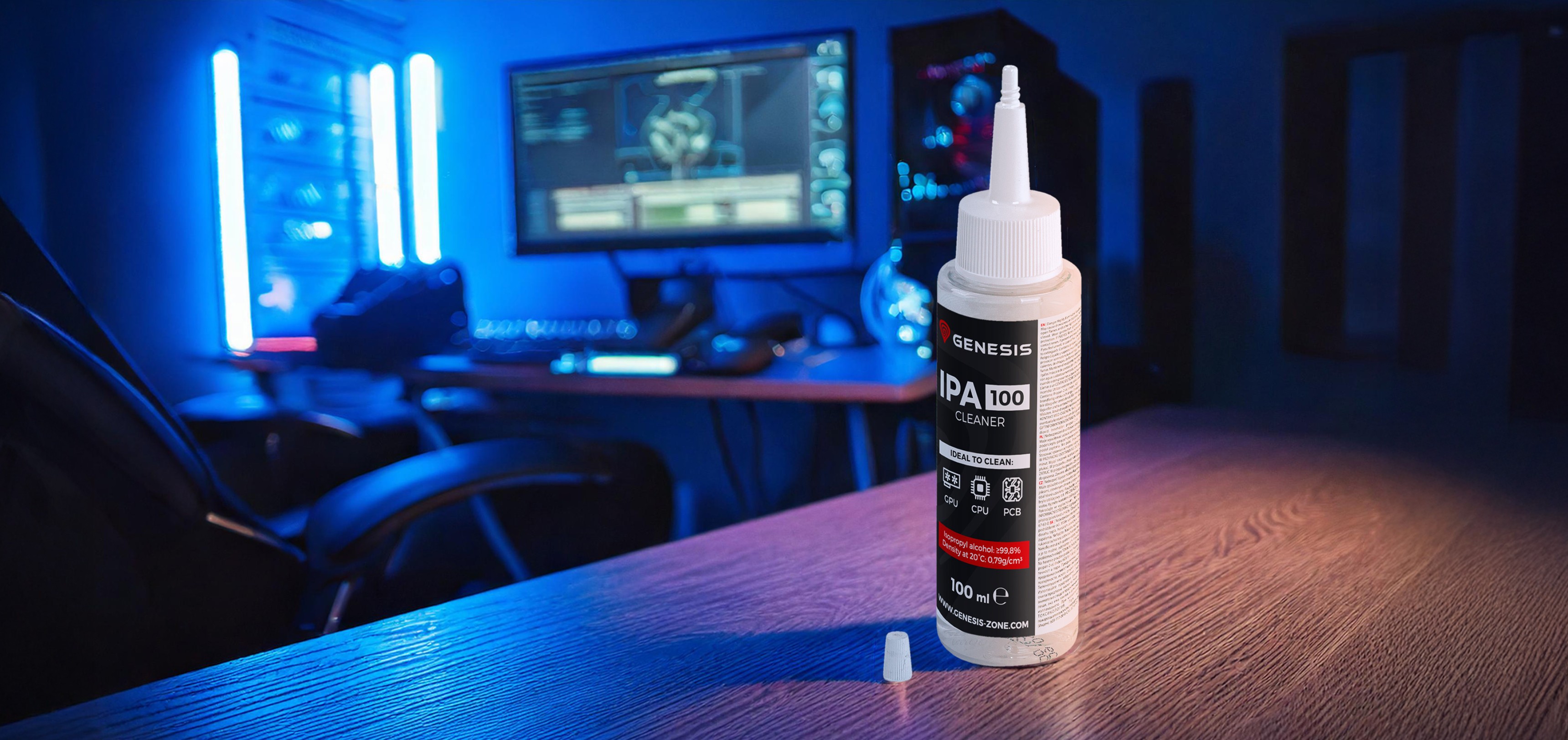 Bouteille de Genesis IPA 100 cleaner (100ml) sur un bureau en bois, avec une installation de jeu et des lumières d'ambiance bleues en arrière-plan.