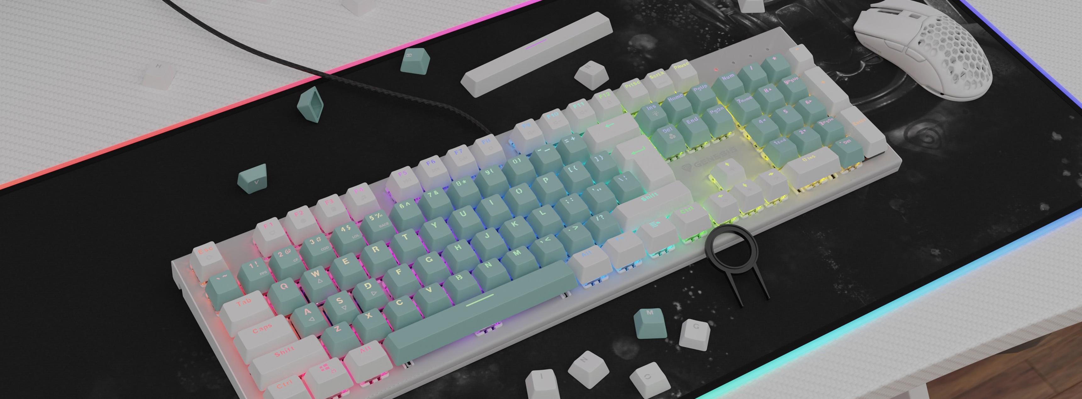 Claviers à double cliché vert menthe sur un clavier rétroéclairé, entouré de petites pièces de clavier blanches et d'une souris gaming.