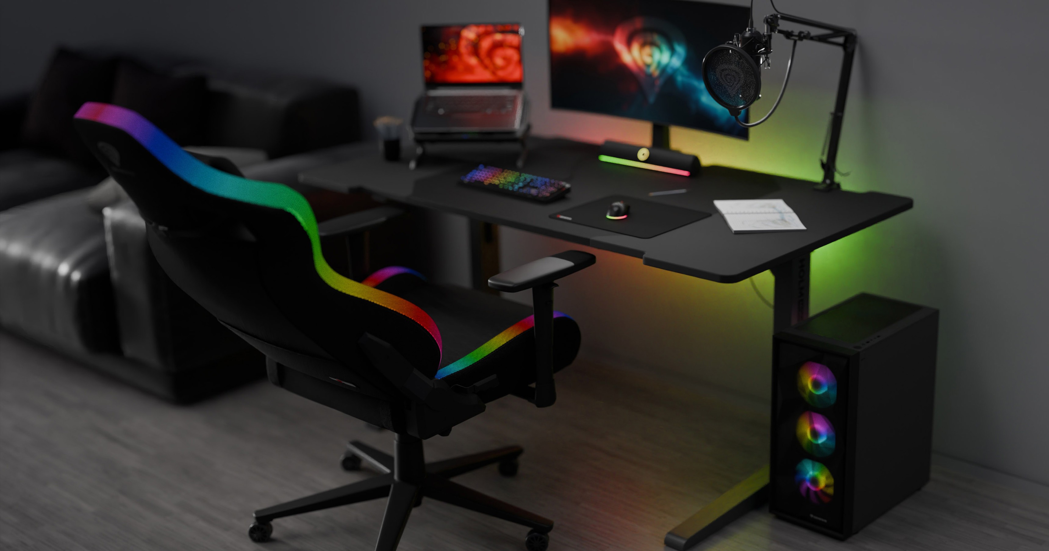 Une chaise de jeu noire avec des accents RVB est placée à côté d'un bureau élégant avec un moniteur, un clavier et une installation de jeu colorée