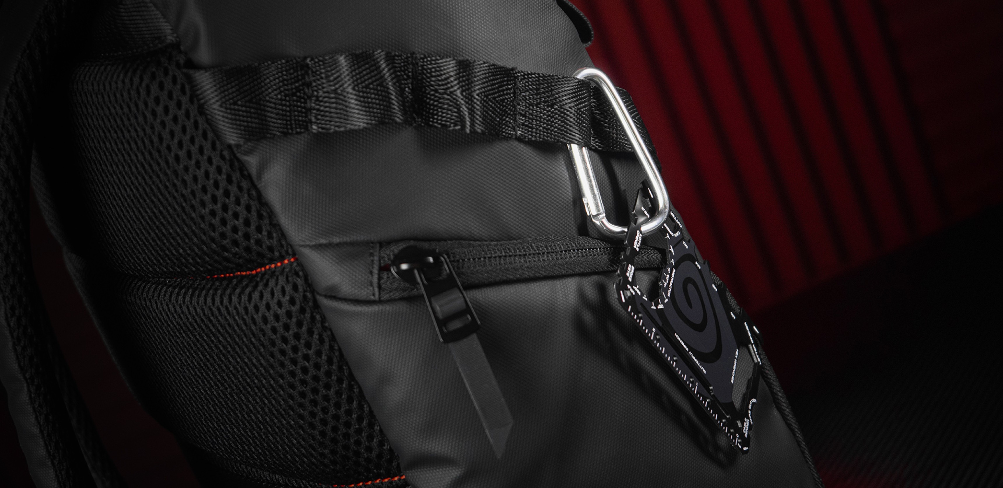 Sac à dos noir pour ordinateur portable avec des détails en filet et un clip fixé sur le côté, conçu pour les ordinateurs portables de 15,6", d'une capacité de 18 litres.